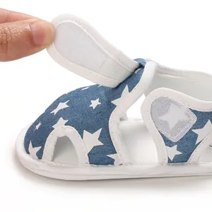 Detalle de sandalia azul para bebé con estampado de estrellas y cierre de velcro ajustable