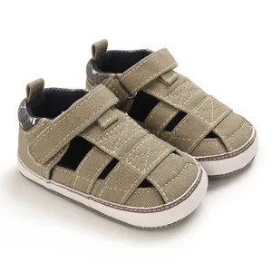 Dettaglio delle scarpe da passeggio per neonati in tela kaki con suola morbida e velcro
