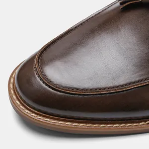 Close-up of premium brown leather loafer showing detailed stitching and material texture