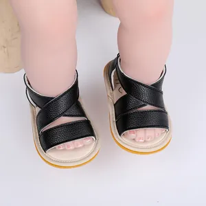 Détail de sandales pour bébé en cuir noir avec semelle en caoutchouc