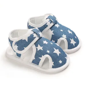 Detalle de sandalias azules para bebé con estrellas blancas y cierre de velcro.