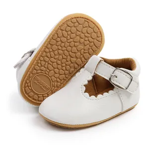 Detailed view of white baby princess shoes with non-slip rubber sole and scalloped edges