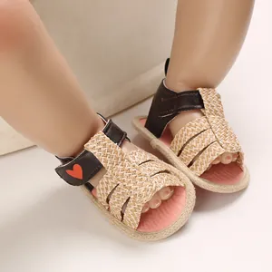 Detailed shot of baby girl summer sandals with straw weave and red heart pattern