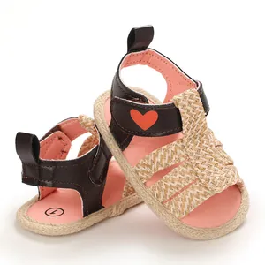 Detailed view of baby girl summer sandals featuring woven texture and red heart detail