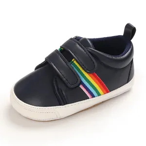 Gros plan d'une chaussure de bébé bleu marine avec des rayures arc-en-ciel
