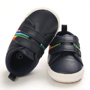 Vue détaillée de chaussures pour bébés bleu marine avec rayures arc-en-ciel et semelle