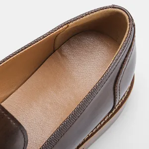 Close-up of brown leather men's loafer showing the soft inner lining and stitching detail