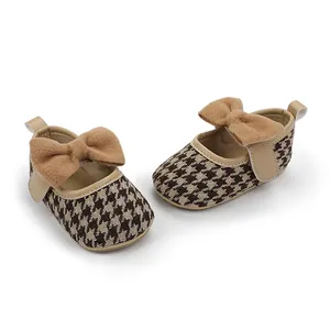 Detailansicht Baby Mädchen Prinzessin Schuhe mit Hahnentrittmuster und Plüschschleife