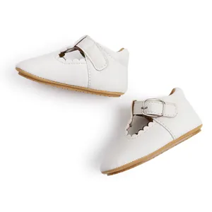 Detail view of white baby princess shoes with scallop edge and soft rubber sole