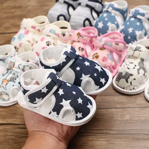 Primer plano de sandalias para bebé azul marino con estampado de estrellas, suela blanda y velcro