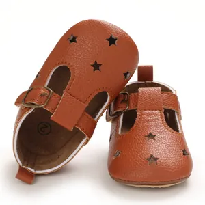 Detail of brown baby leather walking sandals with star cutouts and metal buckles