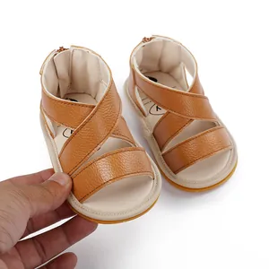Gros plan de sandales d'été en cuir marron pour bébé garçon avec brides croisées