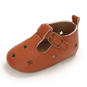 Detailed view of the brown leather baby sandal featuring star-shaped cutouts and a buckle