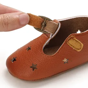 Macro view of brown baby sandal with hollow star patterns and buckle strap detail