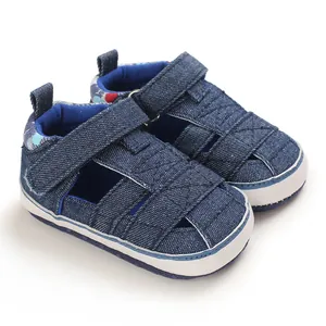 Dettaglio di sandali estivi per neonati in denim blu con suole morbide e velcro