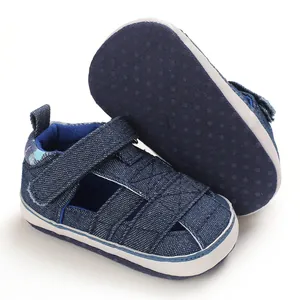 Dettaglio di scarpe primi passi in denim blu per neonato con suola morbida antiscivolo