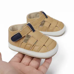 A detailed view of breathable tan faux leather baby sandals held in hand to show scale