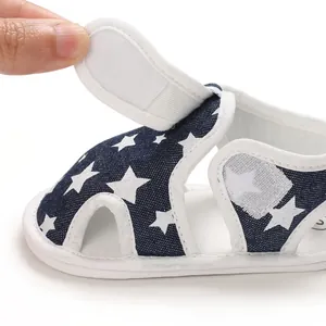 Detalle del cierre de velcro en las sandalias para bebé azul marino con estampado de estrellas