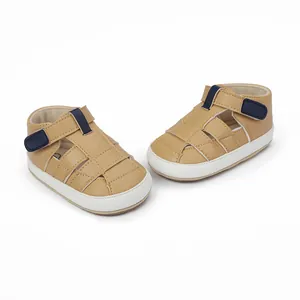 Comfortable soft-soled tan baby walking sandals featuring navy blue Velcro straps.