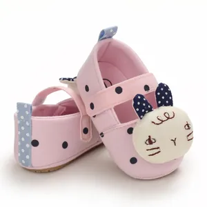 Close-up of pink infant walking shoes featuring cute cartoon rabbit embroidery detail