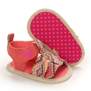Close-up of pink baby sandals with colorful woven straps and soft non-slip soles