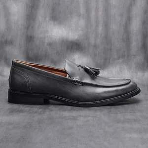 Detailed side profile of men's grey leather tassel loafers business dress shoes.
