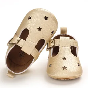 Close-up view of shimmering gold baby sandals with star cutouts and T-strap buckle design