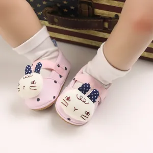 Close-up detail of pink baby walking shoes with cute cartoon rabbit and soft sole