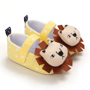 Close-up of cute cartoon lion baby walking shoes with soft soles and yellow dots.