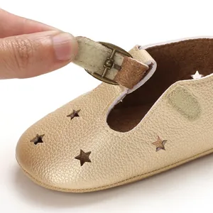 Close-up detail of golden baby walking shoe featuring star cutouts and a Velcro strap