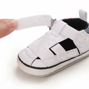 Dettaglio scarpa primi passi bianca per neonato con chiusura a strappo regolabile