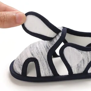 Detalle del cierre de velcro ajustable en una sandalia de bebé con suela blanda.