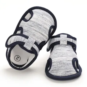 Nahaufnahme von Baby-Sandalen mit weicher Sohle, gestreiftem Stoff und Lochmuster-Design