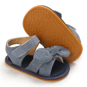 Vista macro de sandalias vaqueras para bebé con detalle de lazo y suela