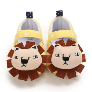 Macro view of the cute cartoon lion decoration on yellow baby pre-walker soft sole shoes