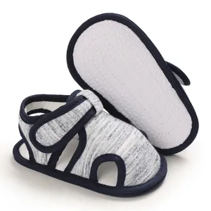 Detalle de sandalias para bebé con suela blanda antideslizante y tejido gris jaspeado