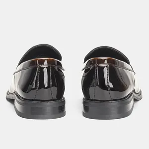 Detailed rear view of polished patent leather men's loafers with classic stitching details