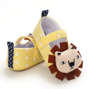 Close-up of yellow baby pre-walker shoes with cute cartoon lion design and soft canvas sole