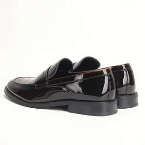 Detail of shiny patent leather men's loafers in a dark brown finish.