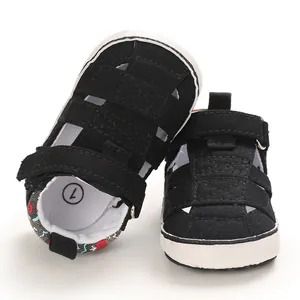 Scarpe primi passi per neonato in tela nera con design traforato e suola morbida bianca