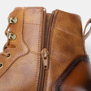 Detailopname van de zijrits en de leertextuur op vintage bruine werkschoenen voor heren.