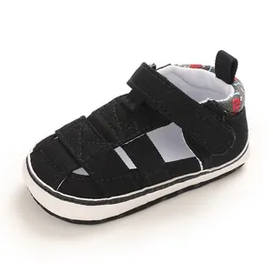 Dettaglio di una scarpa primi passi nera traspirante per neonati con cinturino in velcro