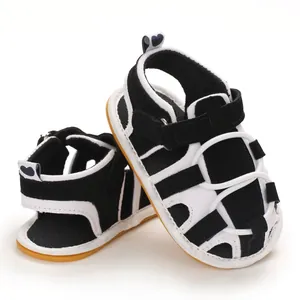 Dettaglio di sandali per neonati in bianco e nero con suola morbida e velcro per 0-1 anni