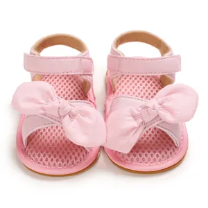 Detalle de sandalias rosas para bebé con lazos decorativos grandes y malla suave transpirable