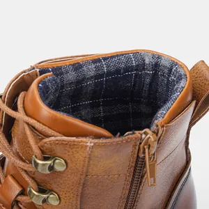 Detail van vintage bruine werkschoen met geruite binnenvoering en zijritssluiting