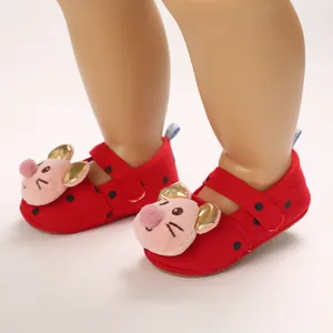 Close-up of red ladybug pattern baby walking shoes with plush cartoon pig face decoration