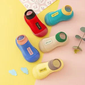 Bunte Kleinkind-Söckchenschuhe mit SELF-CARE-Label auf gelb-rosa Hintergrund