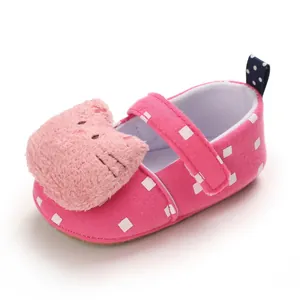 Close-up of pink baby girl walking shoe with cute plush cat and white polka dots