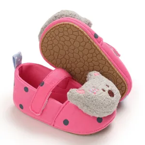 Detailed view of pink polka dot baby girl shoes with soft rubber sole and bear decoration