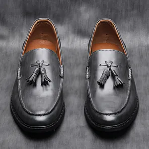 Detail view of men's grey leather loafers with elegant tassel accents.